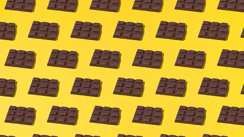 Multiple dark chocolate bars on a yellow background
