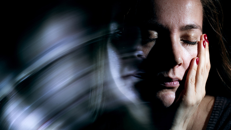 Person's face with motion blurred background, looking faint.